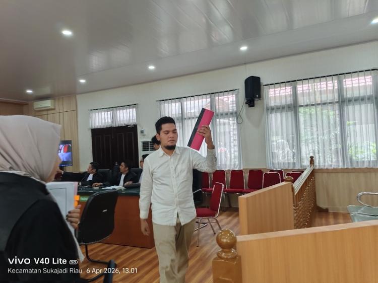 Terdakwa (JA) mengenakan kemeja putih berlengan panjang