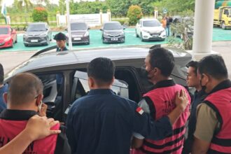 Tiga tersangka mengenakan rompi pink