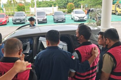 Tiga tersangka mengenakan rompi pink