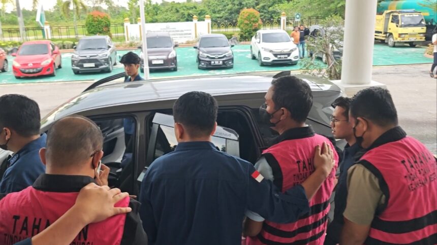 Tiga tersangka mengenakan rompi pink